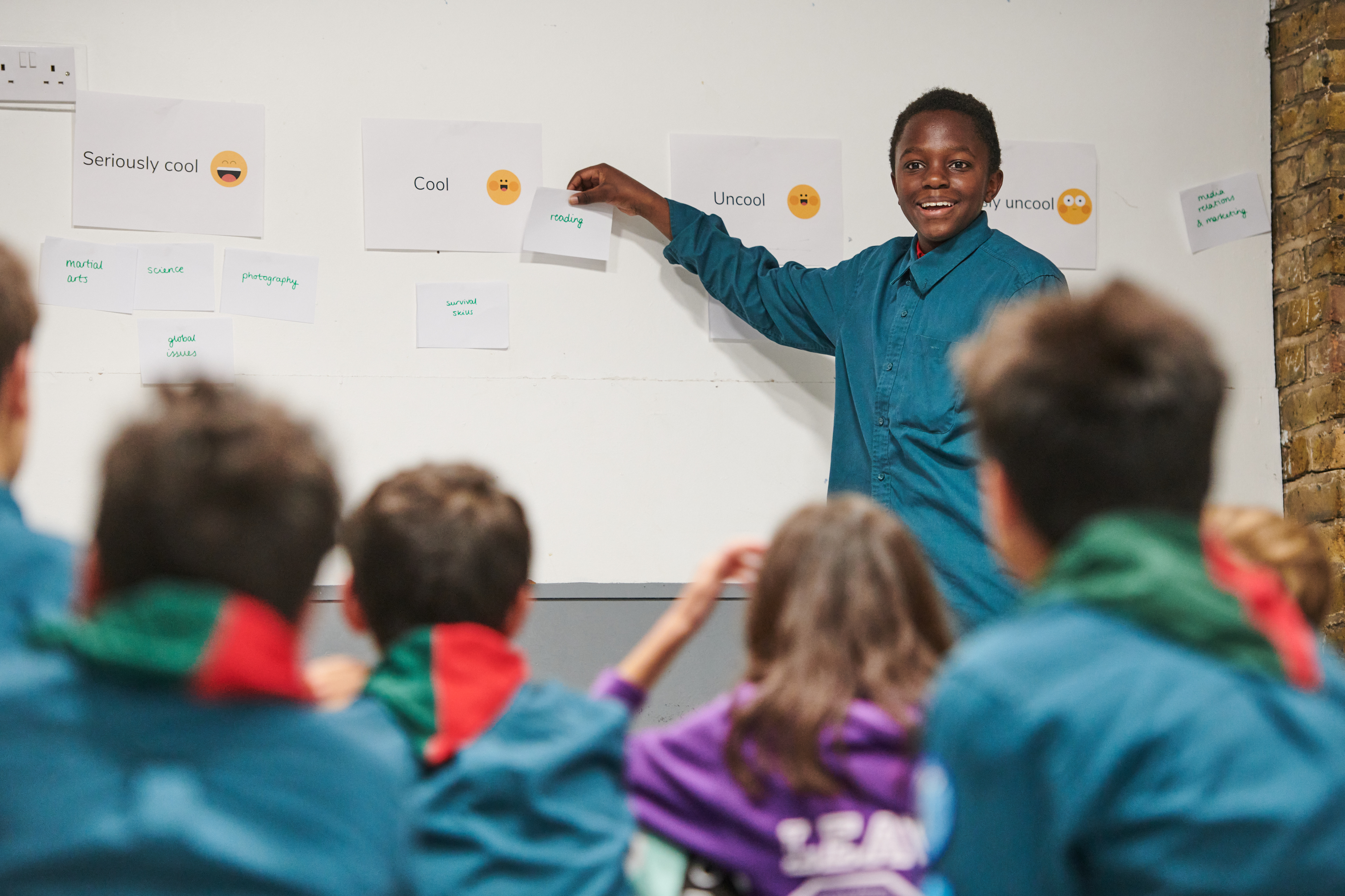 a-young-person-putting-the-activity-reading-under-the-heading-cool-on-a-wall-of-activities